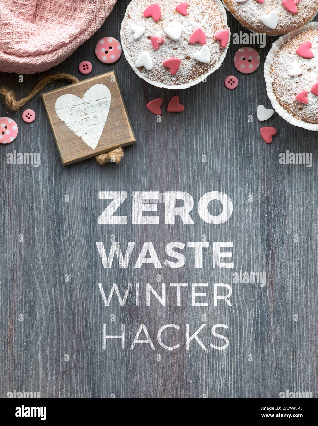 Mit Zucker bestreut Muffins mit rosa und weißen Fondant Zuckerglasur Herzen. Ansicht von oben, Text "Null Abfall winter hacks'. Umweltfreundliche Konzept für Winter celebratio Stockfoto