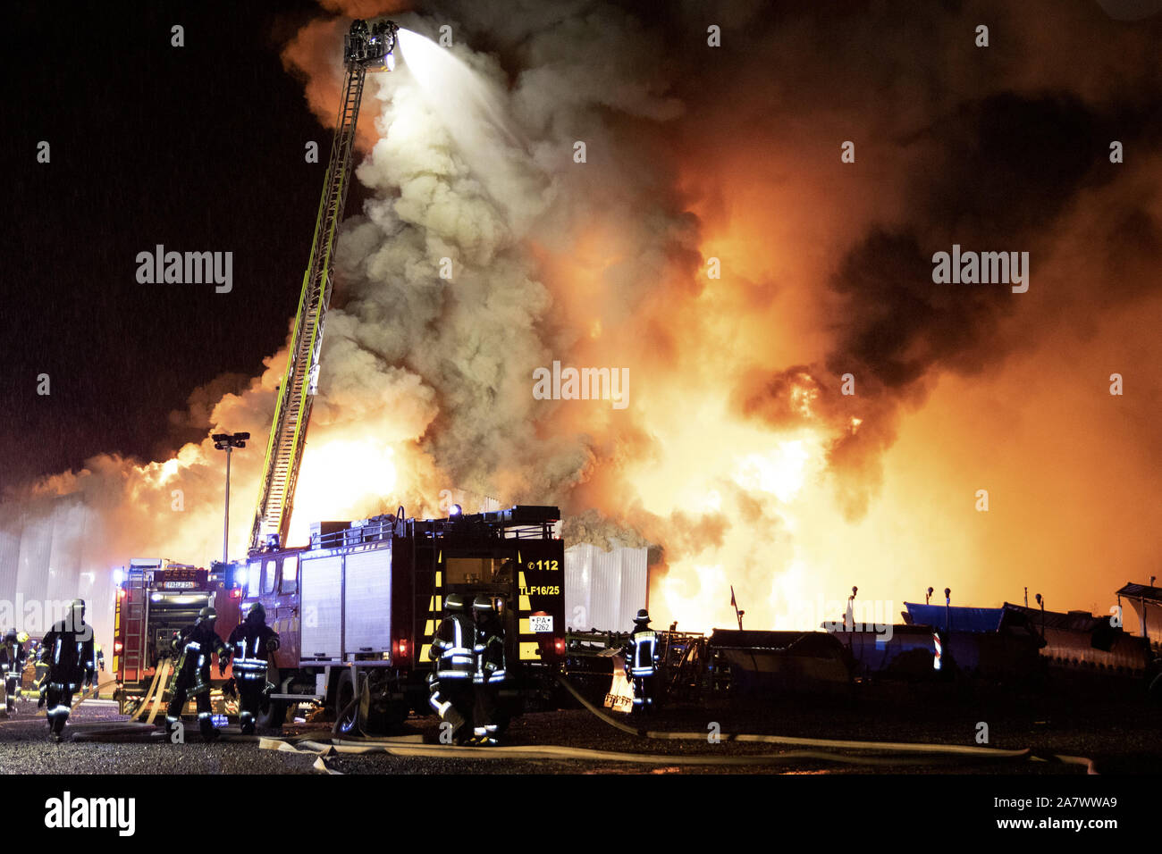 Tittling, Bayern, Deutschland. 4. Nov 2019. Feuerwehrmänner aus einem Lager Feuer. Nach ersten Einschätzungen der Ermittler, das Feuer wahrscheinlich verursacht Schäden in Millionenhöhe. Es wurden ca. 40 Fahrzeuge in der Halle, wie ein Sprecher der Polizei am Montag abend sagte. Er hat noch nicht in der Lage gewesen, keine Informationen über die Art der Fahrzeuge zu geben. Die Ursache des Feuers war auch noch unklar. Die 50 durch 25 Meter grossen Halle vollständig verbrannt. Wegen der starken Rauchentwicklung wurde die Bevölkerung aufgefordert, in die Häuser zu gehen und die Fenster zu schließen. Quelle: dpa Picture alliance/Alamy leben Nachrichten Stockfoto