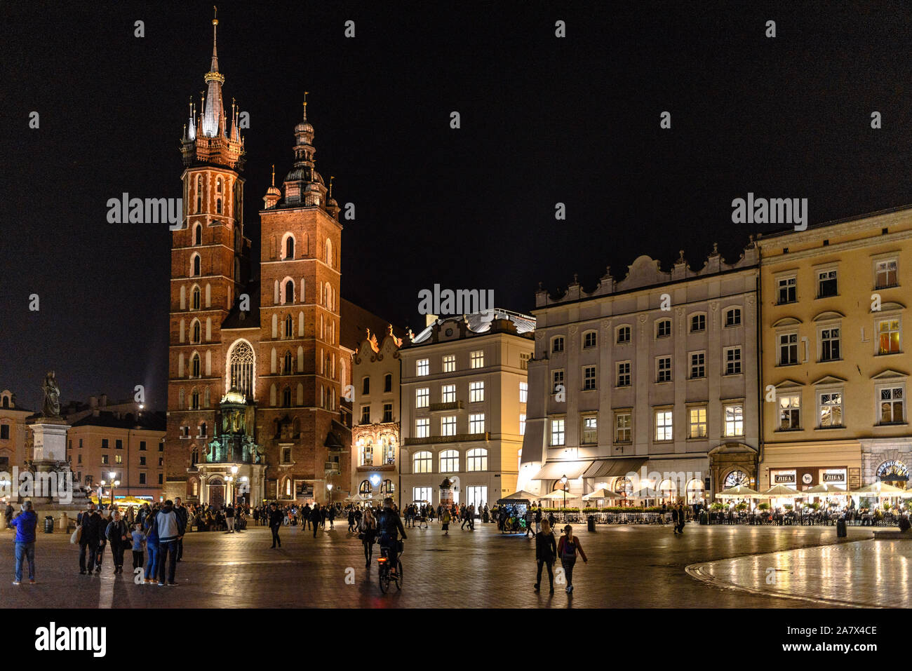 Die Marienkirche in Krakau in den Rynek Glowny Hauptplatz in der Altstadt bei Nacht mit Touristen Stockfoto