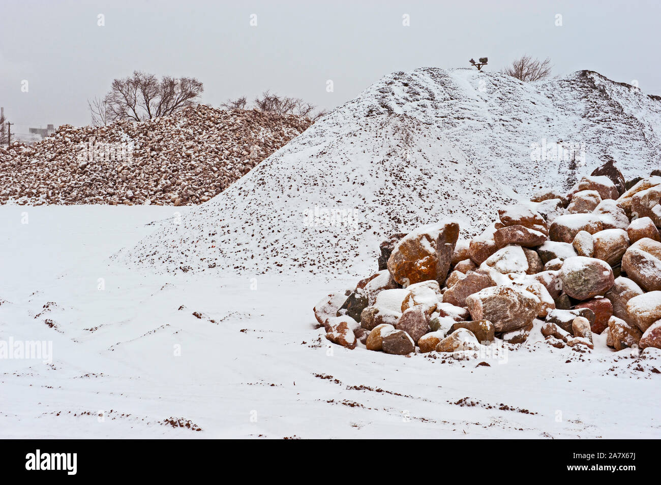 Felsen- und Steinhaufen bei einer örtlichen Straßenbaugesellschaft im Winter. Ludington, Michigan, USA. Stockfoto
