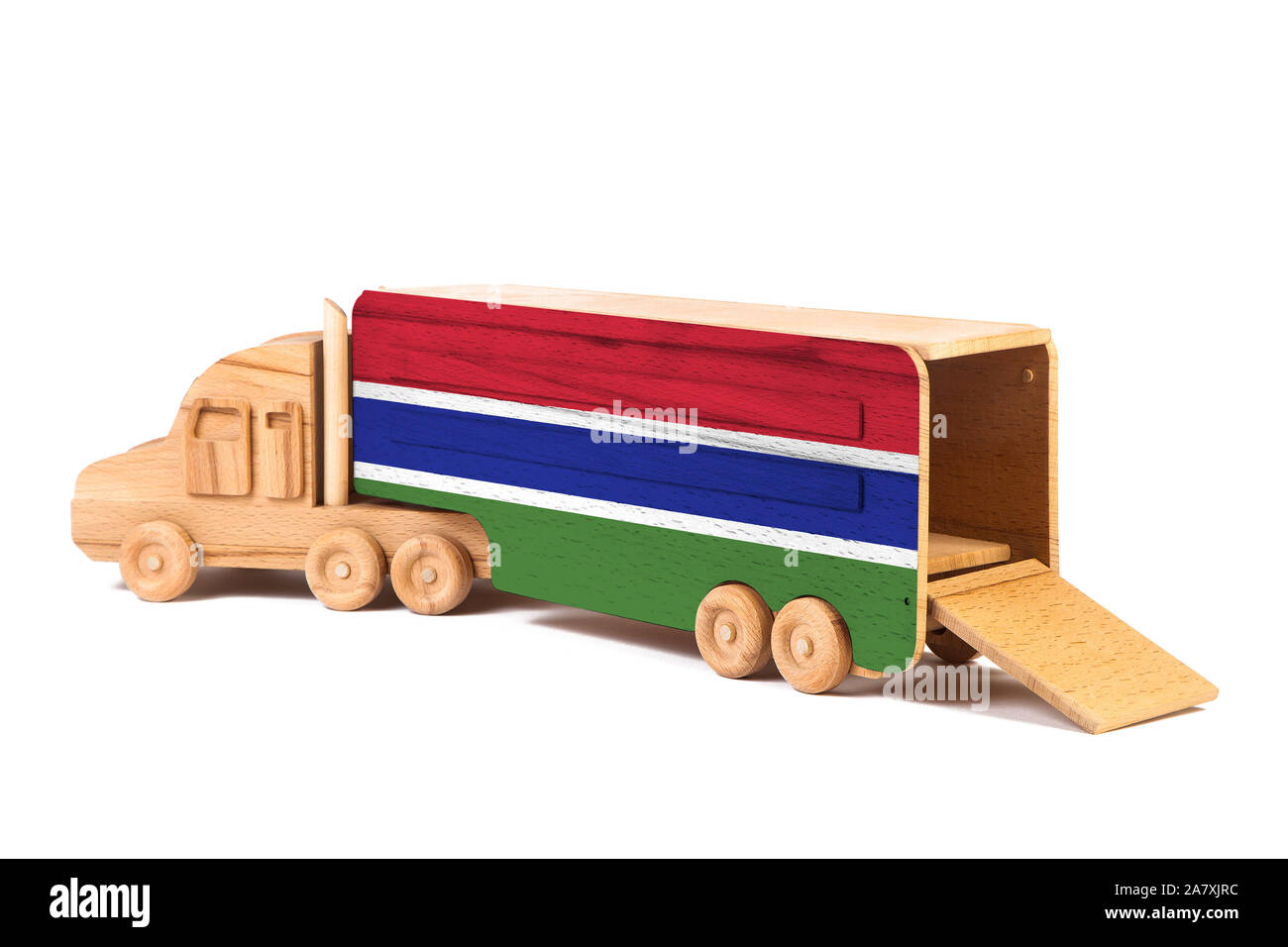Nahaufnahme einer Holz Spielzeug-LKW mit einem gemalten Flagge Gambia. Das Konzept der export-import, Transport, die Lieferung von Waren Stockfoto