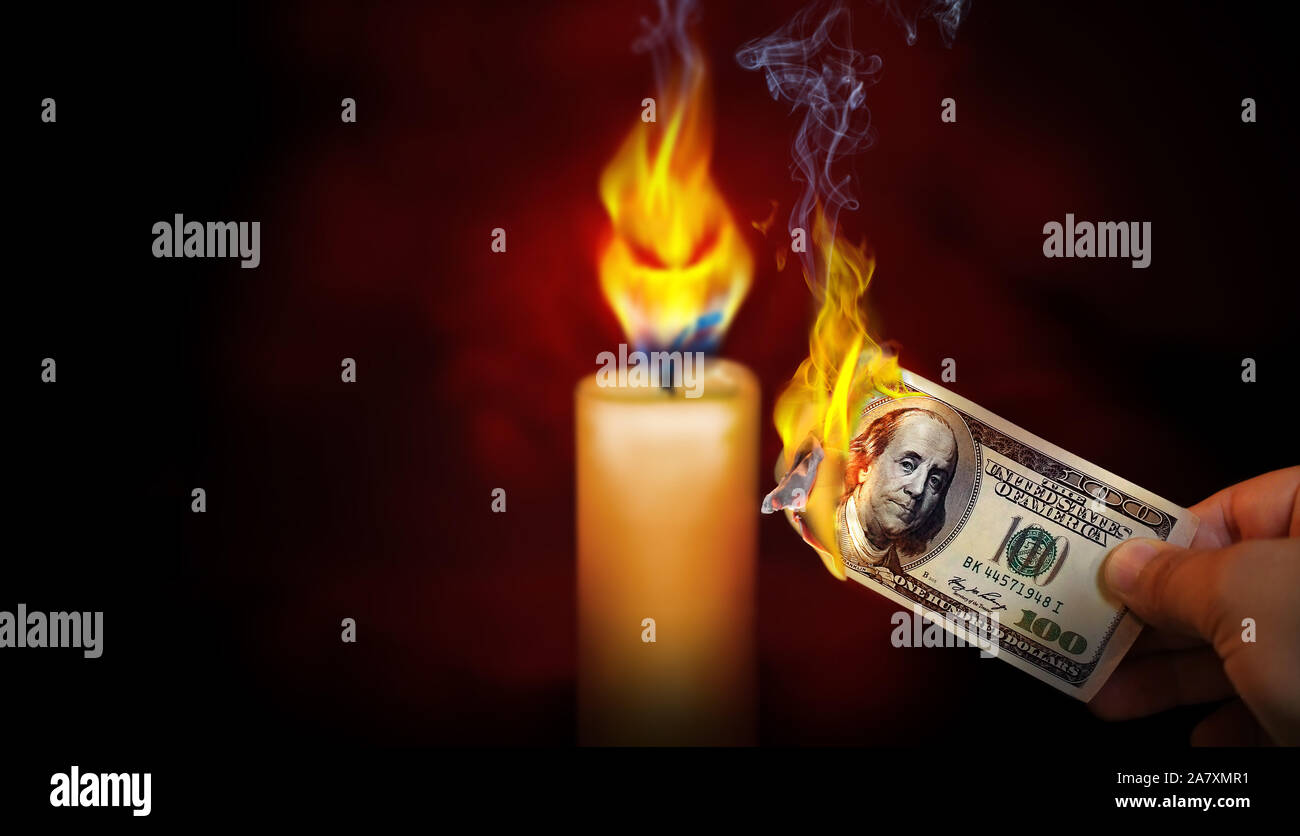 Hand mit einem brennenden 100 Dollar bill Geld mit einem bösen Blick flame Kerze in den Hintergrund. Stockfoto