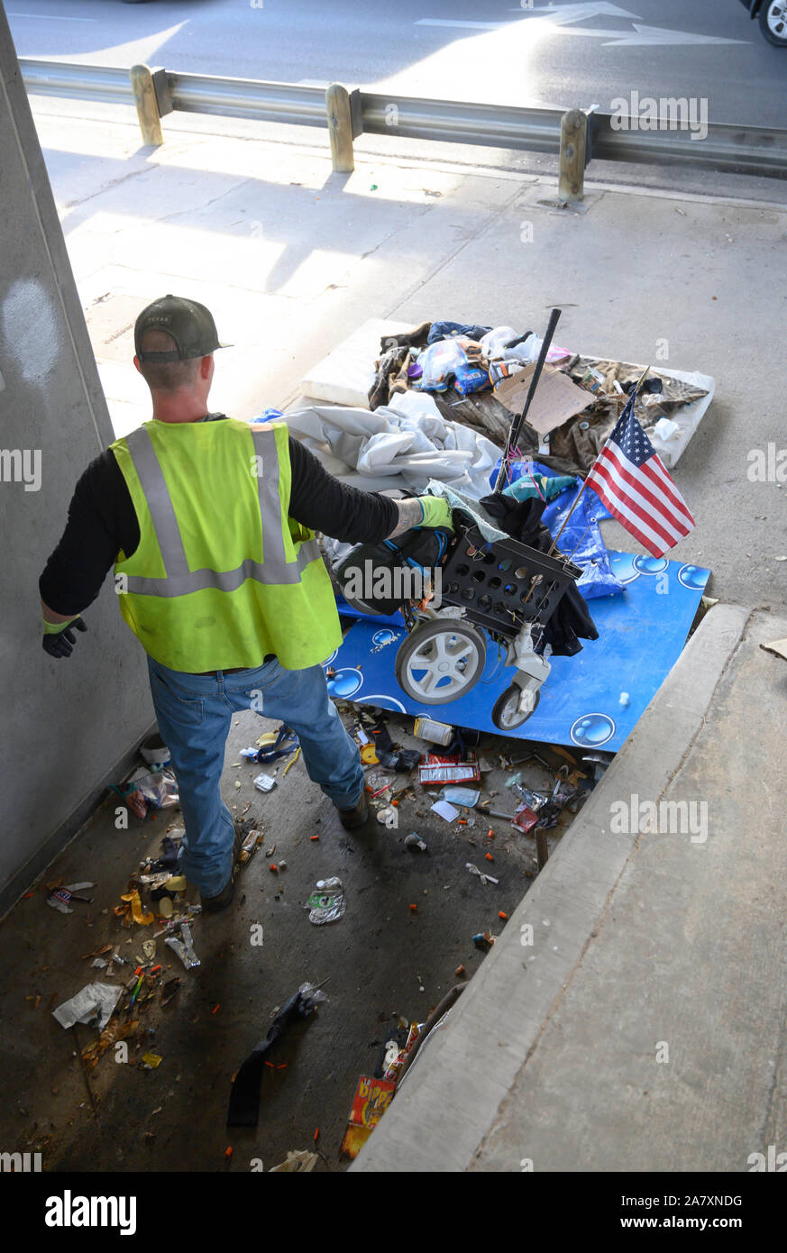 Verkehrsministerium Auftragnehmer räumt einem Obdachlosen Lager unter einer Autobahnbrücke in Austin. Texas reg. Greg Abbott bestellt die Beseitigung von Obdachlosen Camps auf öffentlichen Vorfahrt auf 17 Seiten rund um die Stadt. Stockfoto