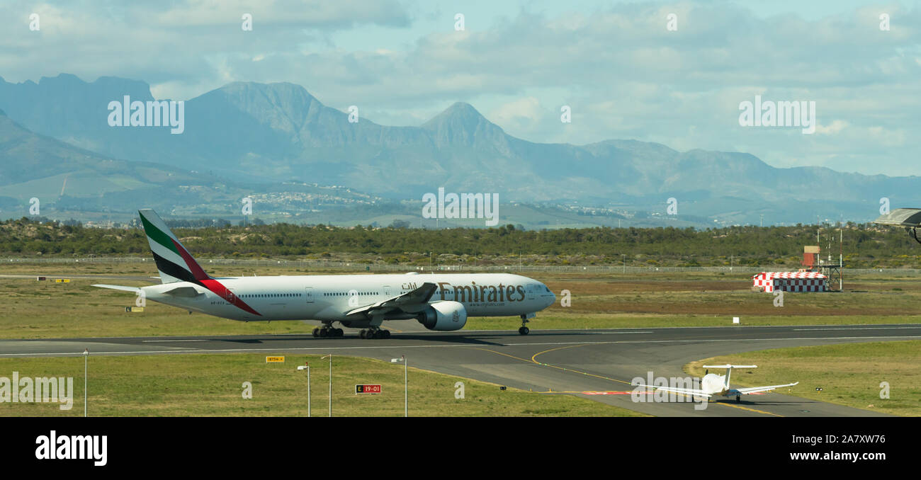 Emirates Airline Boeing 777 kommerziellen Flug auf der Start- und Landebahn am Flughafen Kapstadt vor dem Hintergrund der Berge Stockfoto