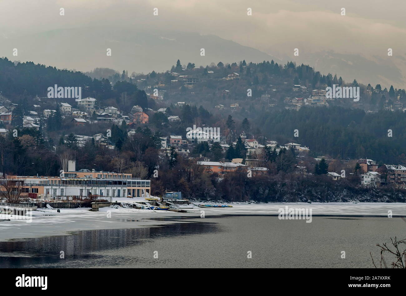 Winter Szene mit gefrorenen See, schneebedeckten Berge, Lichtung, Wald- und Wohnviertel von bulgarischen Dorf Pancharevo, Sofia, Bulgarien Stockfoto