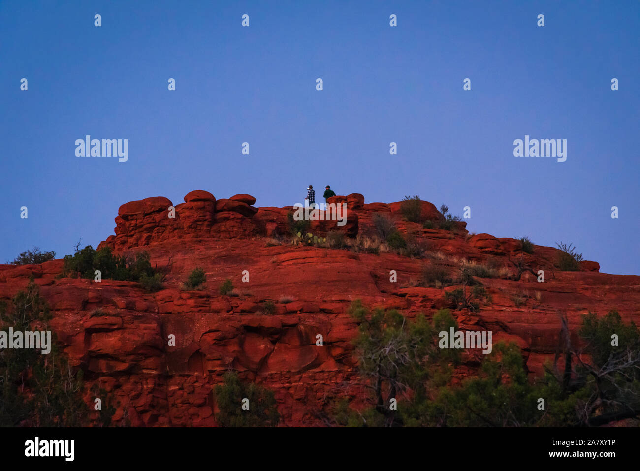 Am Abend Foto von zwei männlichen Wanderer auf einem roten Rock Hill in der Nähe des Bell Rock Trail in Sedona. Stockfoto