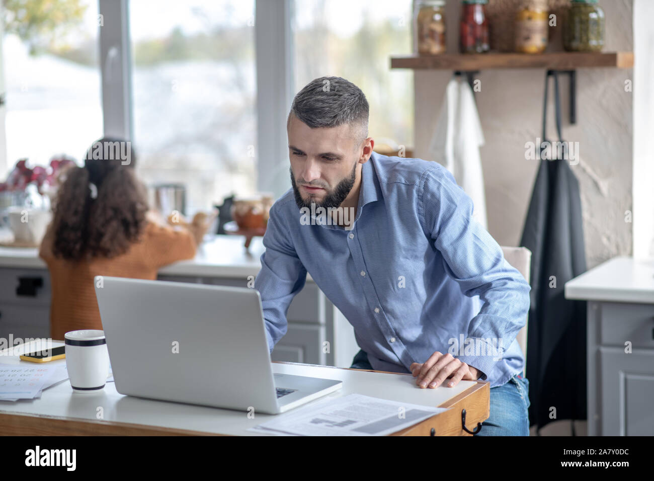 Besetzt Vater Lesen von E-Mails beim Sitzen in der Küche Stockfoto