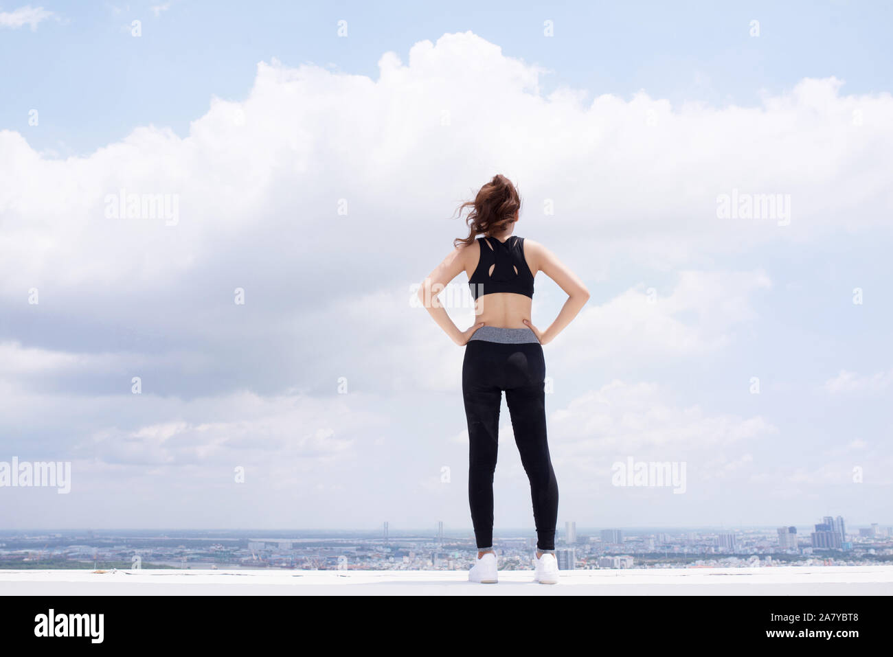 Jolly Mädchen in Sportswear steht auf der Terrasse und freuen uns Stockfoto