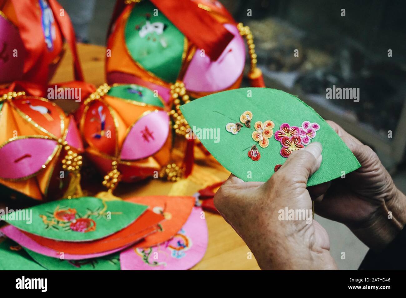 Jingxi, China Guangxi Zhuang autonomen Region. 4 Nov, 2019. Handwerkerin Huang Selami macht eine gestickte Ball in Jiuzhou antike Stadt Jingxi City, South China Guangxi Zhuang autonomen Region, November 4, 2019. Jiuzhou ist als Heimat des Chinesischen bestickte Kugeln betrachtet. Die Kugeln zurück mehr als 2.000 Jahren. Sie haben in der Regel 12 "blütenblätter",- oder kegelförmige Seide Taschen, die in den alten Zeiten mit roten Bohnen oder Getreide vor bestickt mit Vögel oder Blumen als Zeichen von Glück gefüllt waren. Credit: Cui Bowen/Xinhua/Alamy leben Nachrichten Stockfoto