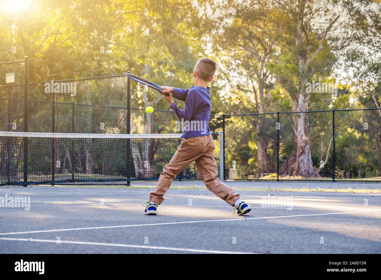 Australische Junge spielt Tennis im Freien Gericht in South Australia Stockfoto