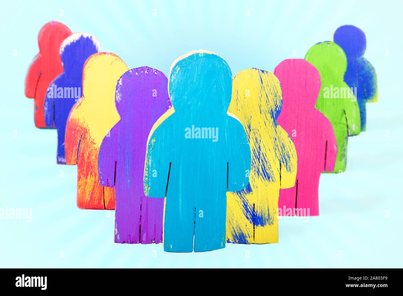 Verschiedene Figuren aus Holz mit blauem Hintergrund, Konzept Team Leader, Solidarität und Zusammenhalt Stockfoto