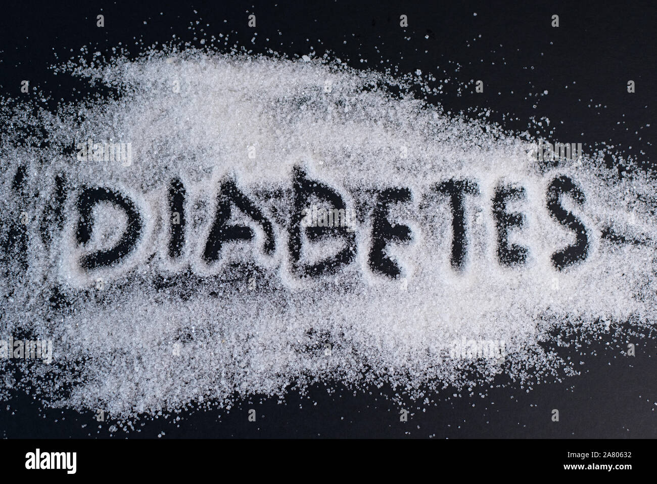 Haufen Zucker mit handschriftlichen DIABETES Wort auf schwarzem Hintergrund. Konzept der Diabetes, ungesunde Ernährung und Gesundheit Stockfoto