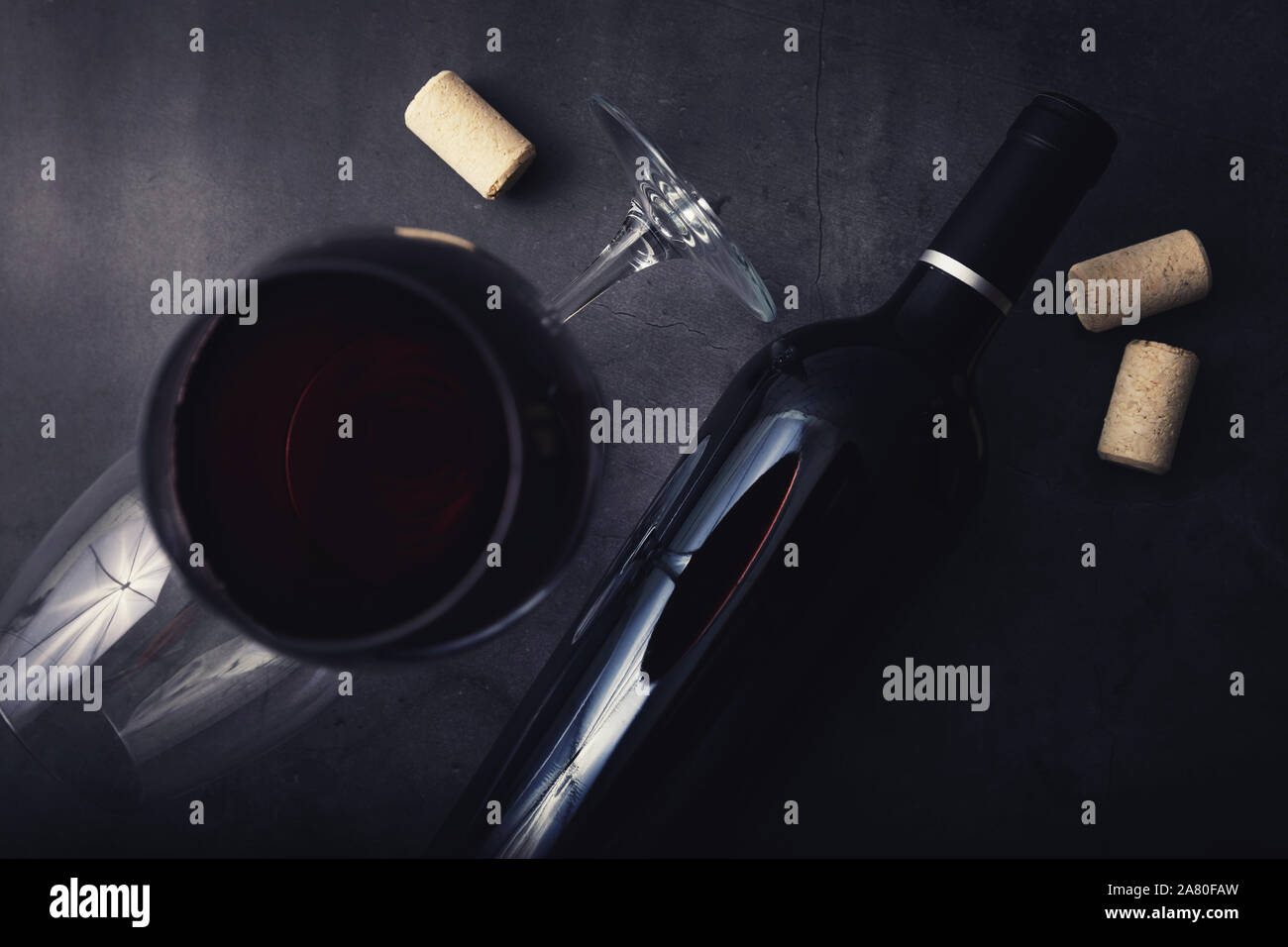 Rotwein Flasche und Glas auf schwarzem Marmor Stein Hintergrund. top View Stockfoto