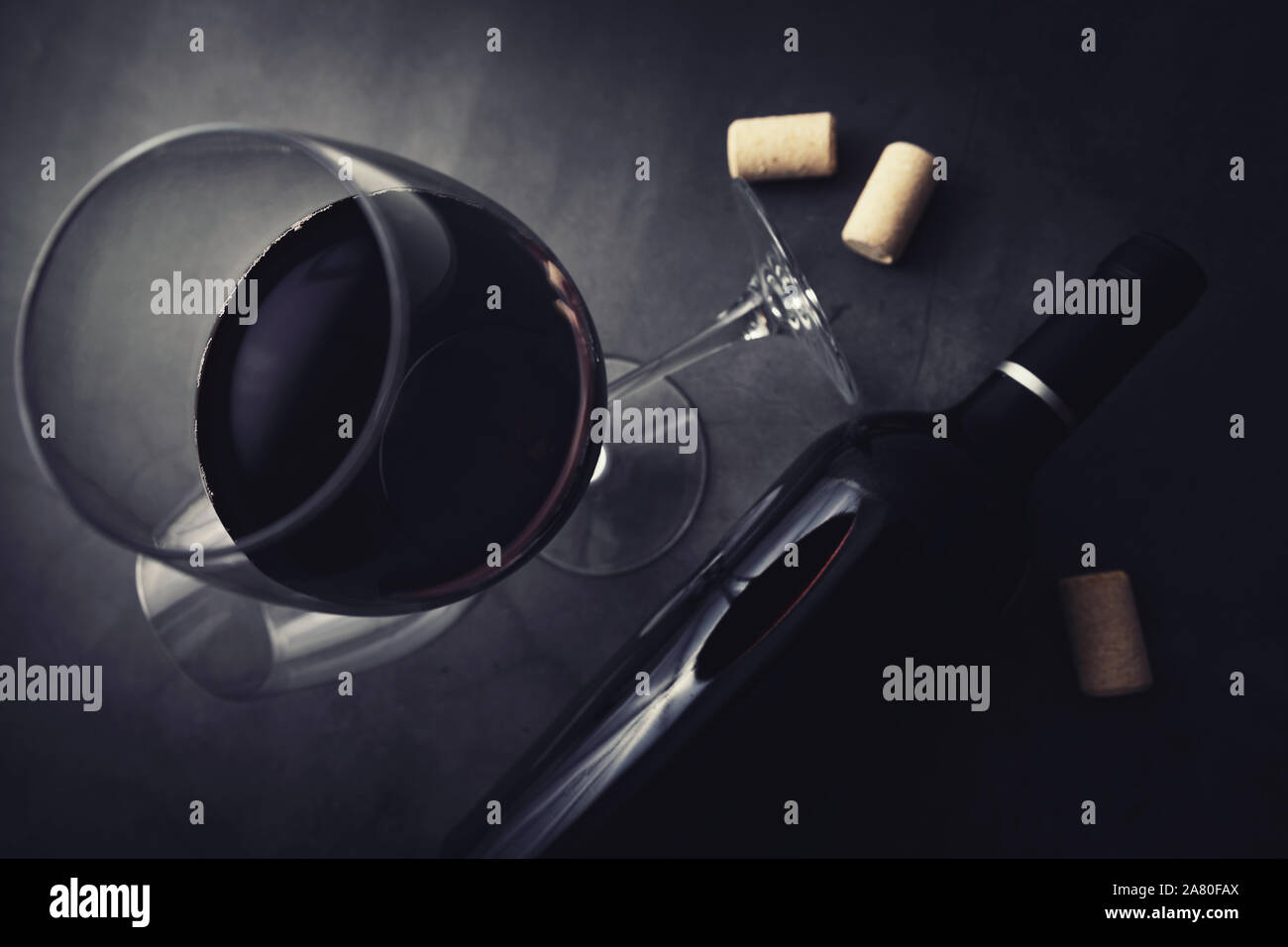 Rotwein Flasche und Glas auf schwarzem Marmor Stein Hintergrund. top View Stockfoto