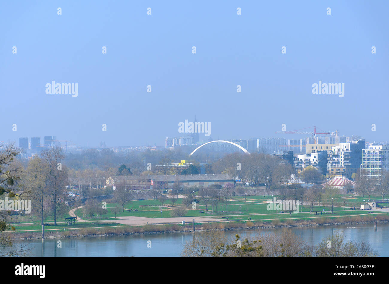 Moderne Stadt auf einem smoggy Tag mit reduzierter Sichtbarkeit einer Waterfront Park und die Innenstadt von Gebäuden mit Blick auf eine Bogenbrücke der Abstand Stockfoto