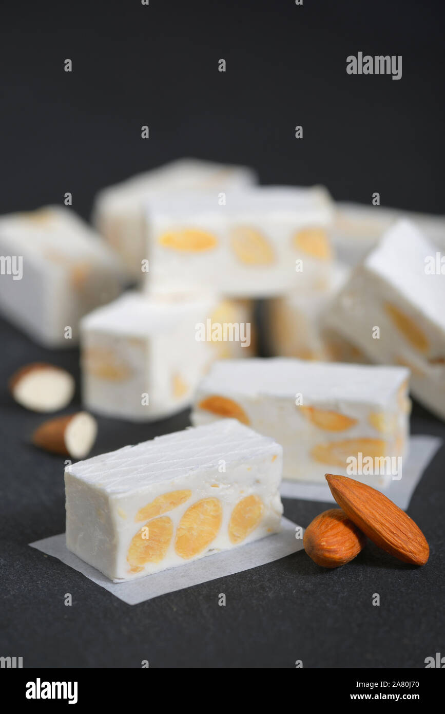 Weißer Nougat mit Mandeln auf schwarzen Ardesia Teller Stockfoto