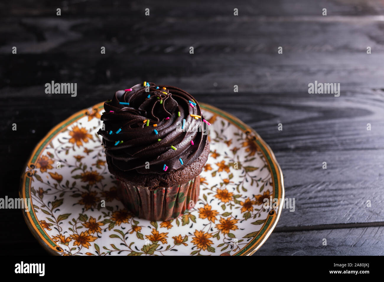 Dramatische essen Schokolade Kuchen mit Streuseln auf dunklen Moody Hintergrund Stockfoto