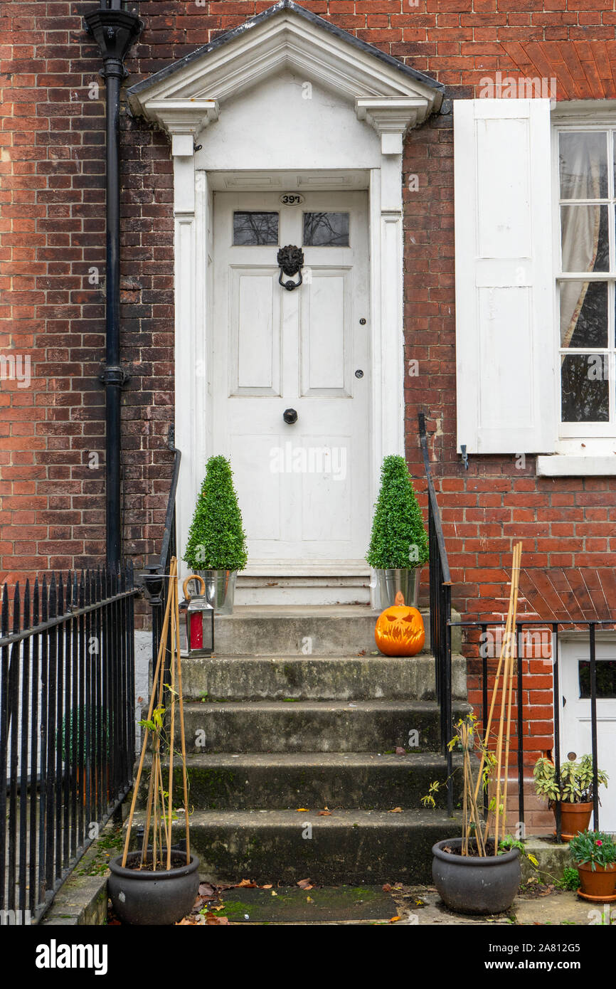 Die Vorderseite eines englischen Haus mit einem geschnitzten Kürbis oder Jack-o-Lantern auf dem Step Stockfoto