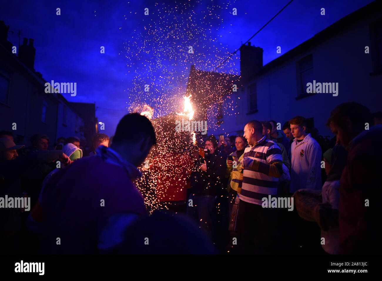 Kinder von der Ortschaft Ottery St Mary in Devon tragen traditionelle Brennen tar Barrel durch die Straßen des Dorfes am Lagerfeuer Nacht. Stockfoto