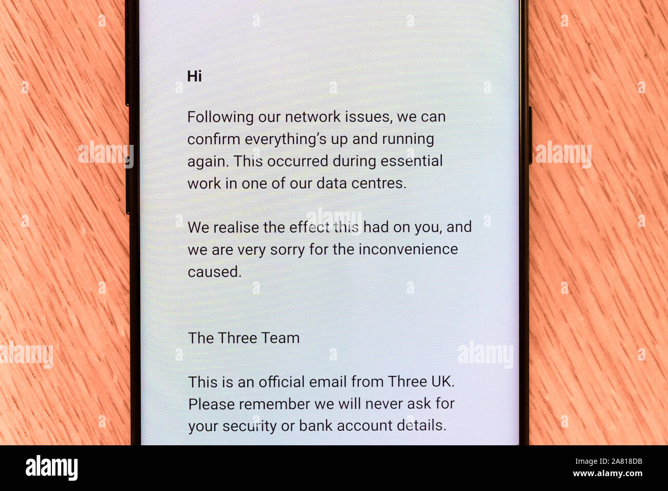 Eine E-Mail von drei auf einem Smartphone - eine britische Mobilfunkanbieter - entschuldigt sich für eines der letzten Netzwerkausfall Stockfoto