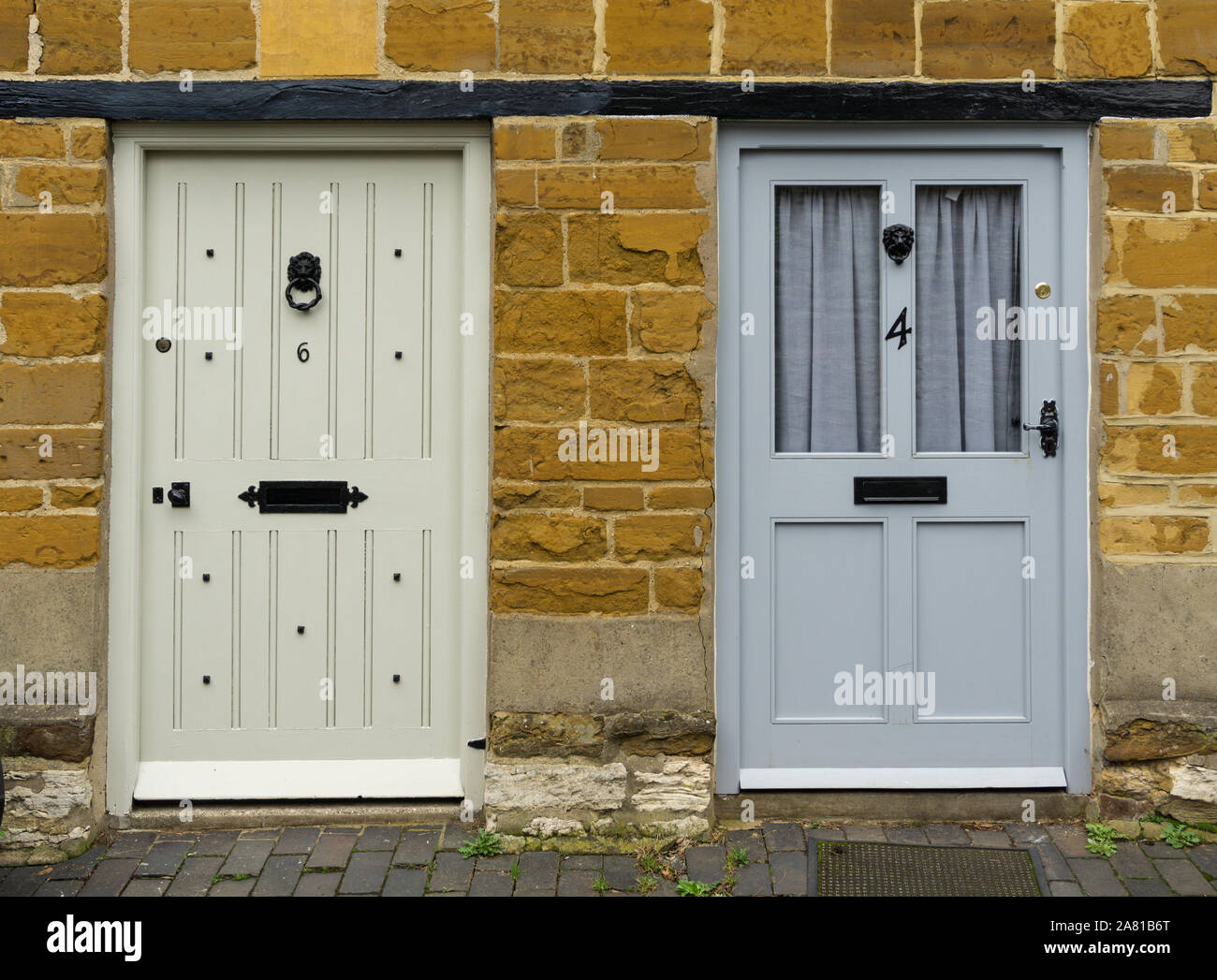 Paar angrenzenden vorderen Türen in eine Terrasse aus Stein gebauten Hütten im Dorf Collingtree, Northamptonshire, Großbritannien Stockfoto