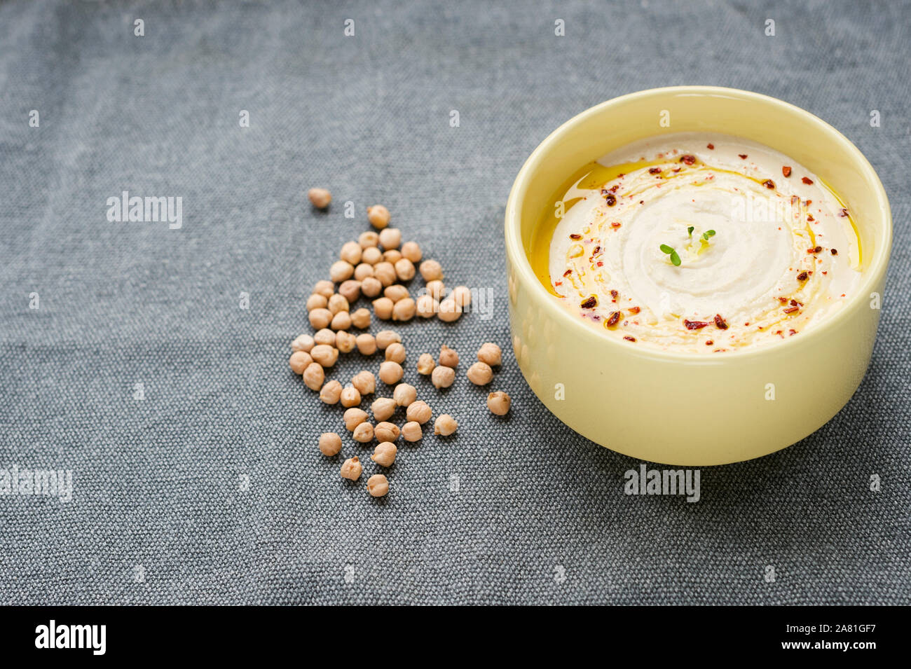 Hausgemachte cremigen Hummus mit Olivenöl und Gewürzen auf den textillle Hintergrund. Kichererbse Hummus. selektive Fokus, horizontal. Stockfoto