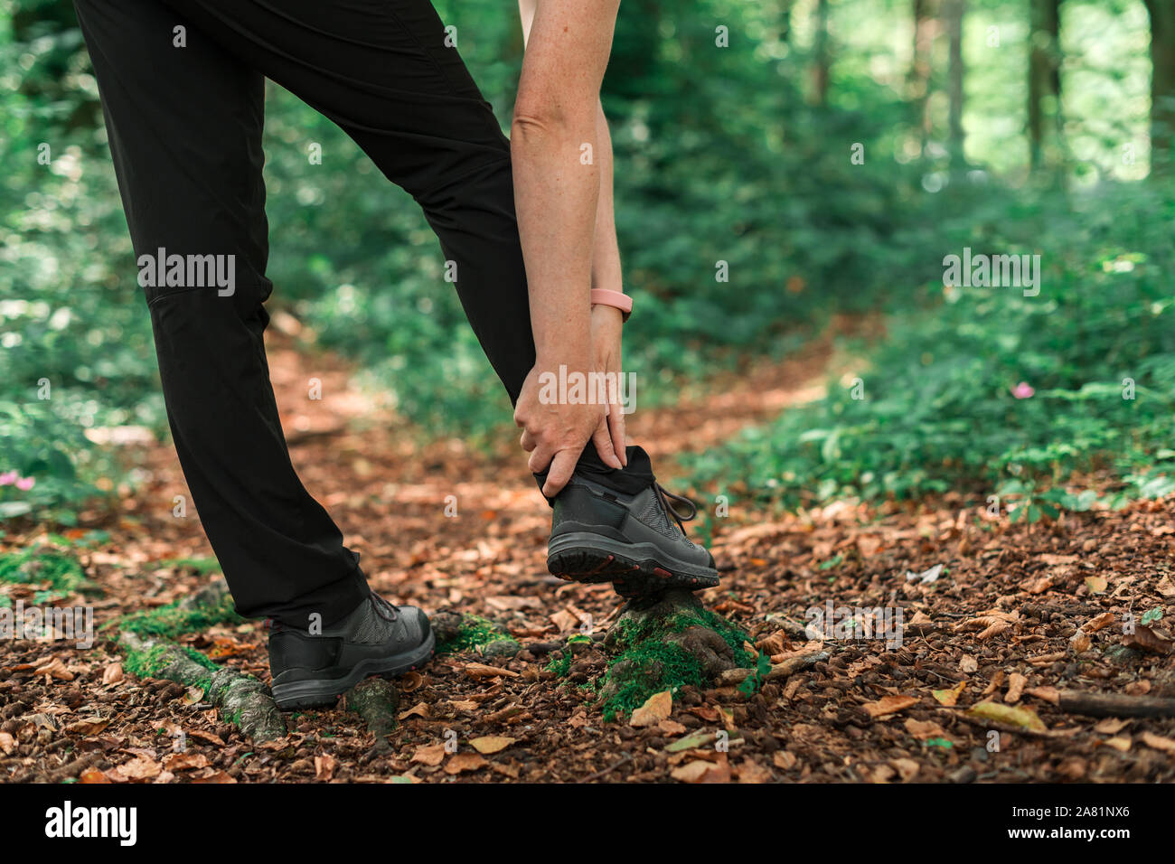 Weibliche Wanderer mit knöchelverletzung im Wald bei Outdoor trekking Aktivität, selektiver Fokus Stockfoto