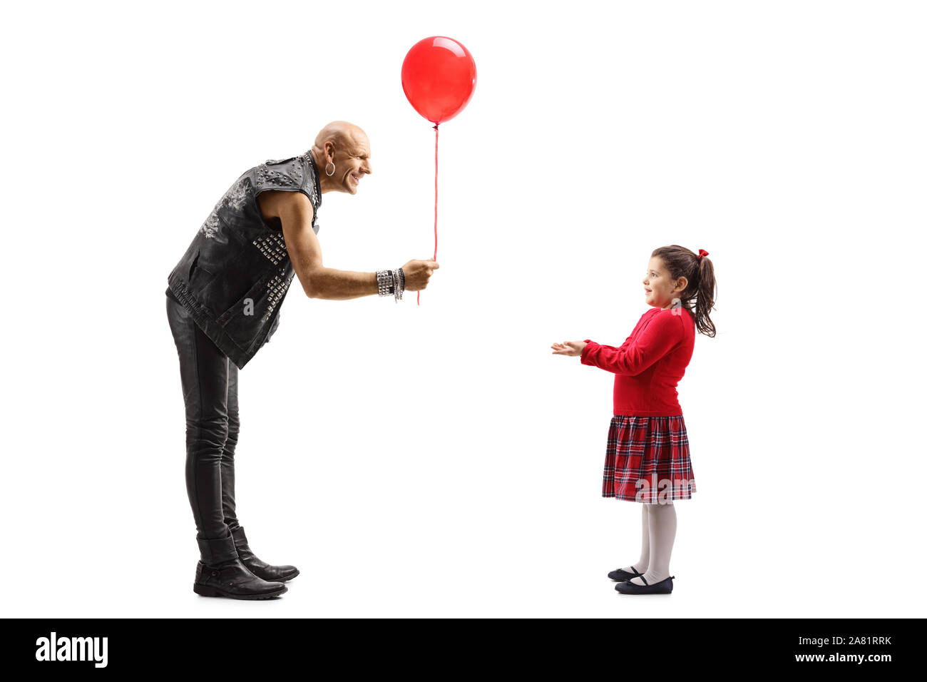 Volle Länge geschossen von einem männlichen Rock Star mit einem roten Ballon zu einem kleinen Mädchen auf weißem Hintergrund Stockfoto