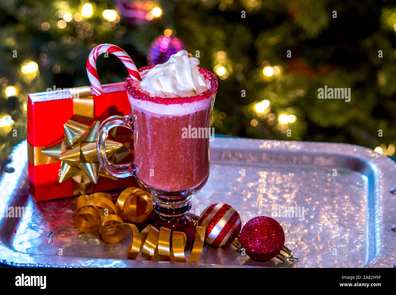Sahne und eine Zuckerstange sind die perfekte Beilage für diese rote, gefroren Weihnachten Cocktail Stockfoto