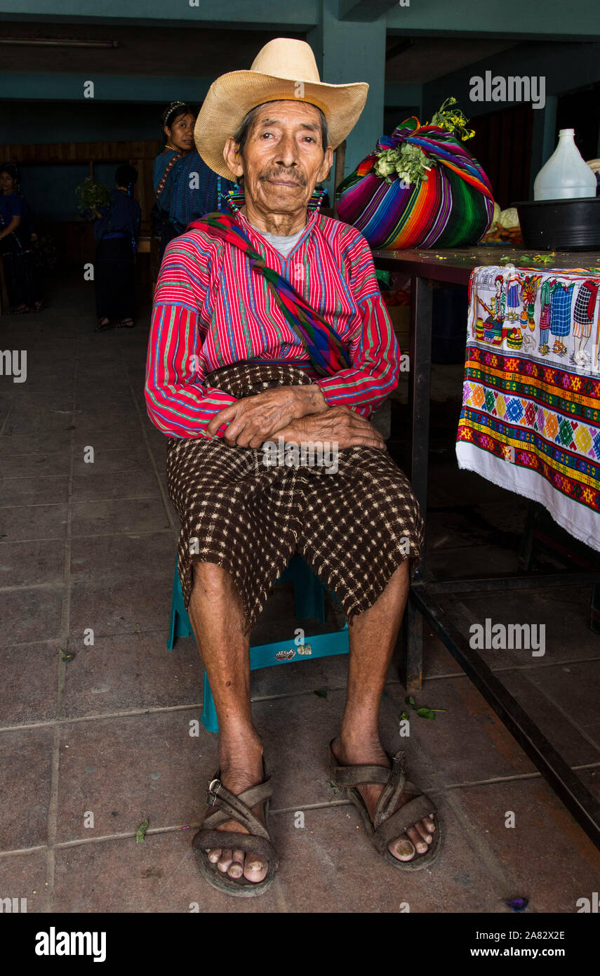 Eine 80-jährige Maya Bauer sitzt in den Markt in San Antonio Palopó, Guatemala, tragen die typische Kleid seiner Stadt, einschließlich einer hand-woven Shirt. Stockfoto