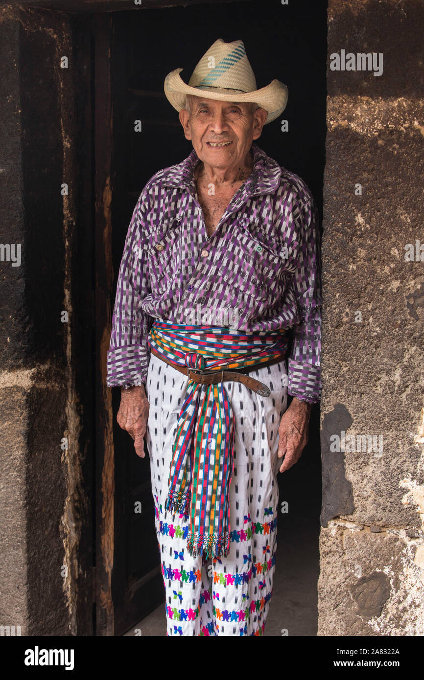 Jahr 90 alte Tzutujil Maya Mann in traditioneller Kleidung steht in der Tür von seinem Haus in San Pedro La Laguna, Guatemala. Stockfoto