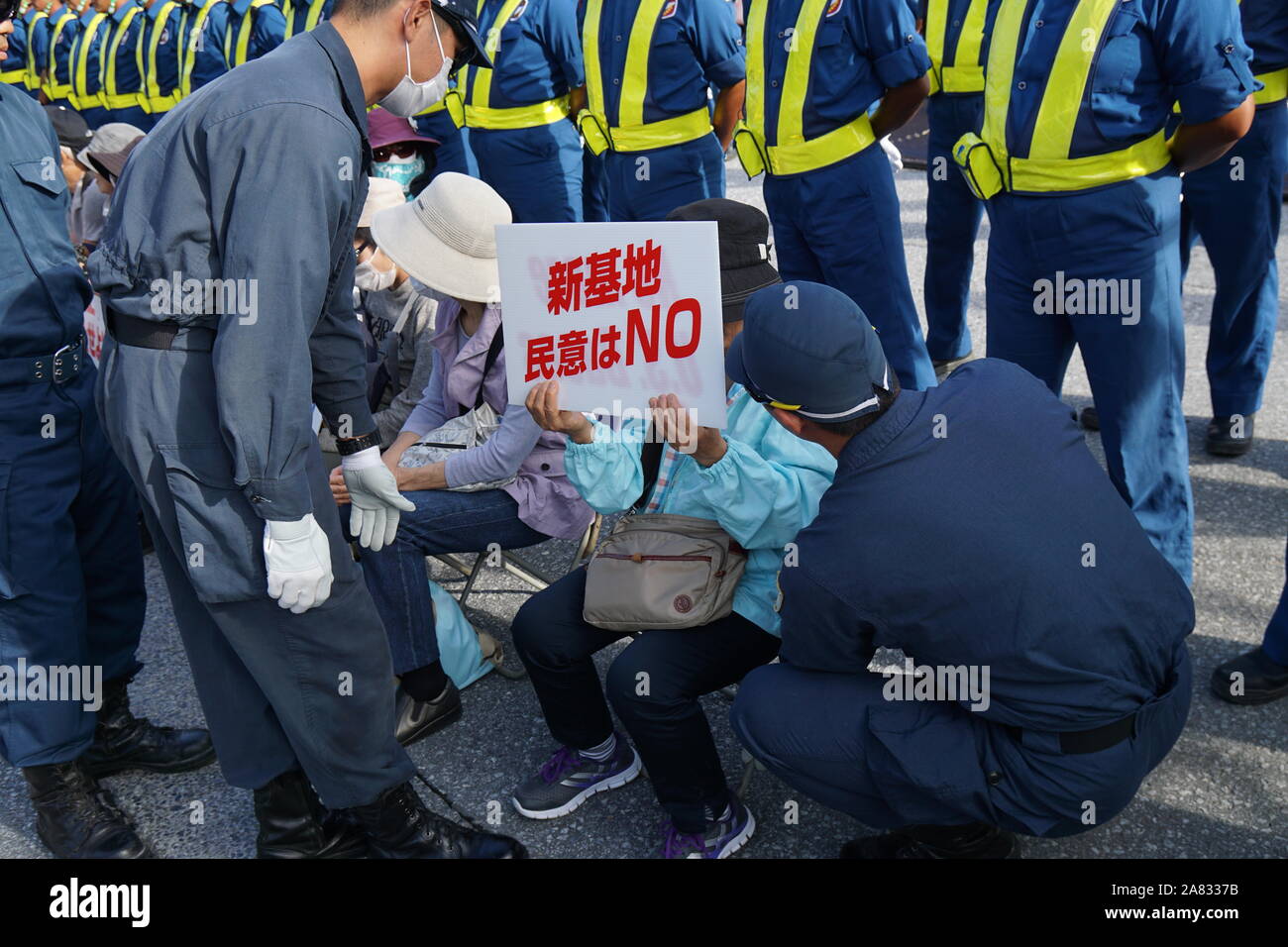 Nago, Japan. 05 Nov, 2019. Polizisten eine Demonstrantin hält ein Plakat während der Demonstration zu konfrontieren. Demonstranten fordern US-Militärbasis Belastung in Okinawa als Präfektur markierten 47 Jahre seit der Rückkehr nach Japan in diesem Jahr. Credit: SOPA Images Limited/Alamy leben Nachrichten Stockfoto
