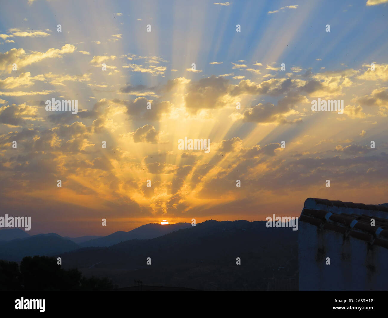 Rising Sun casting Strahlen auf die Wolken am frühen Morgen andalusische Landschaft Stockfoto