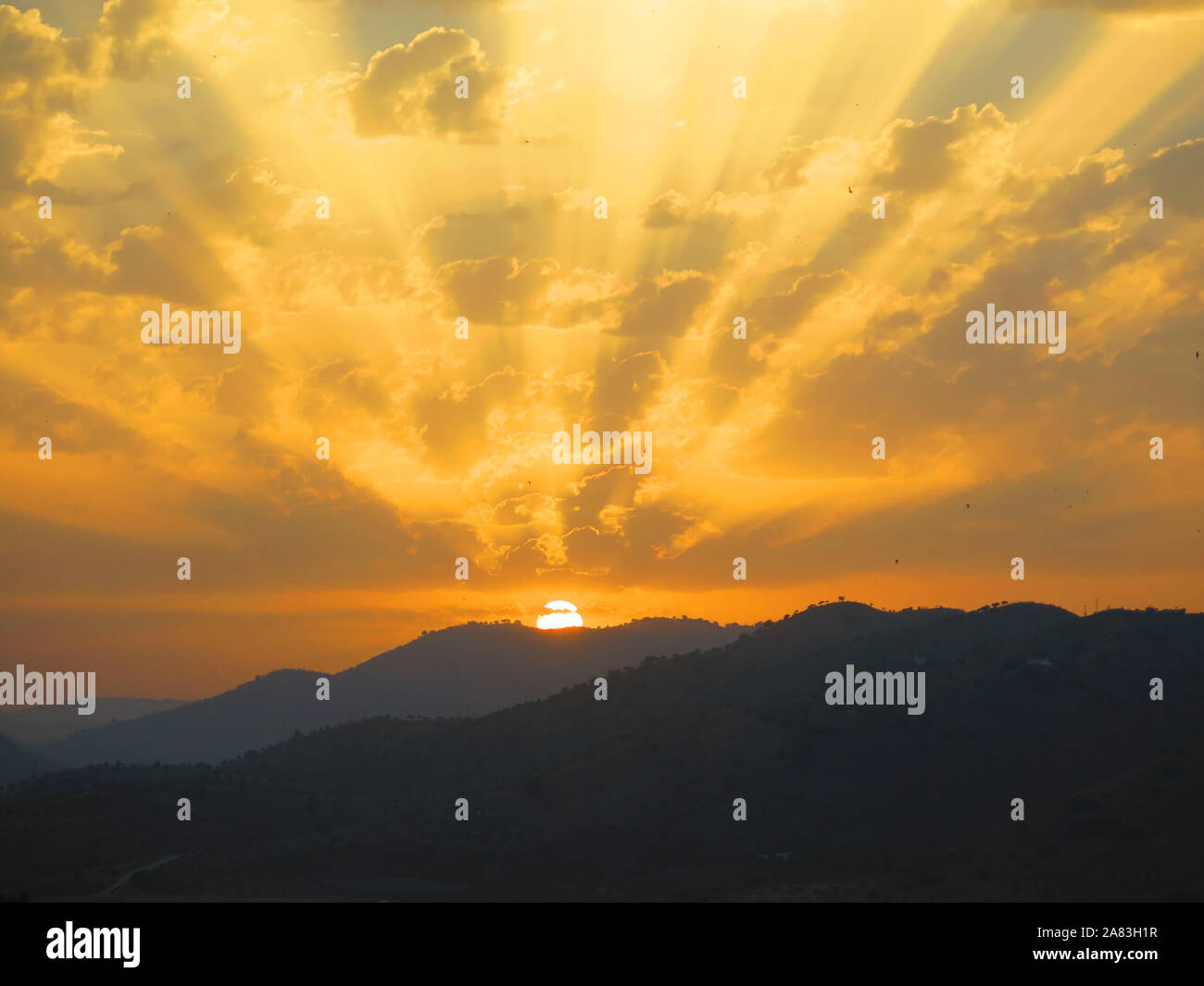 Rising Sun casting Strahlen auf die Wolken am frühen Morgen andalusische Landschaft Stockfoto