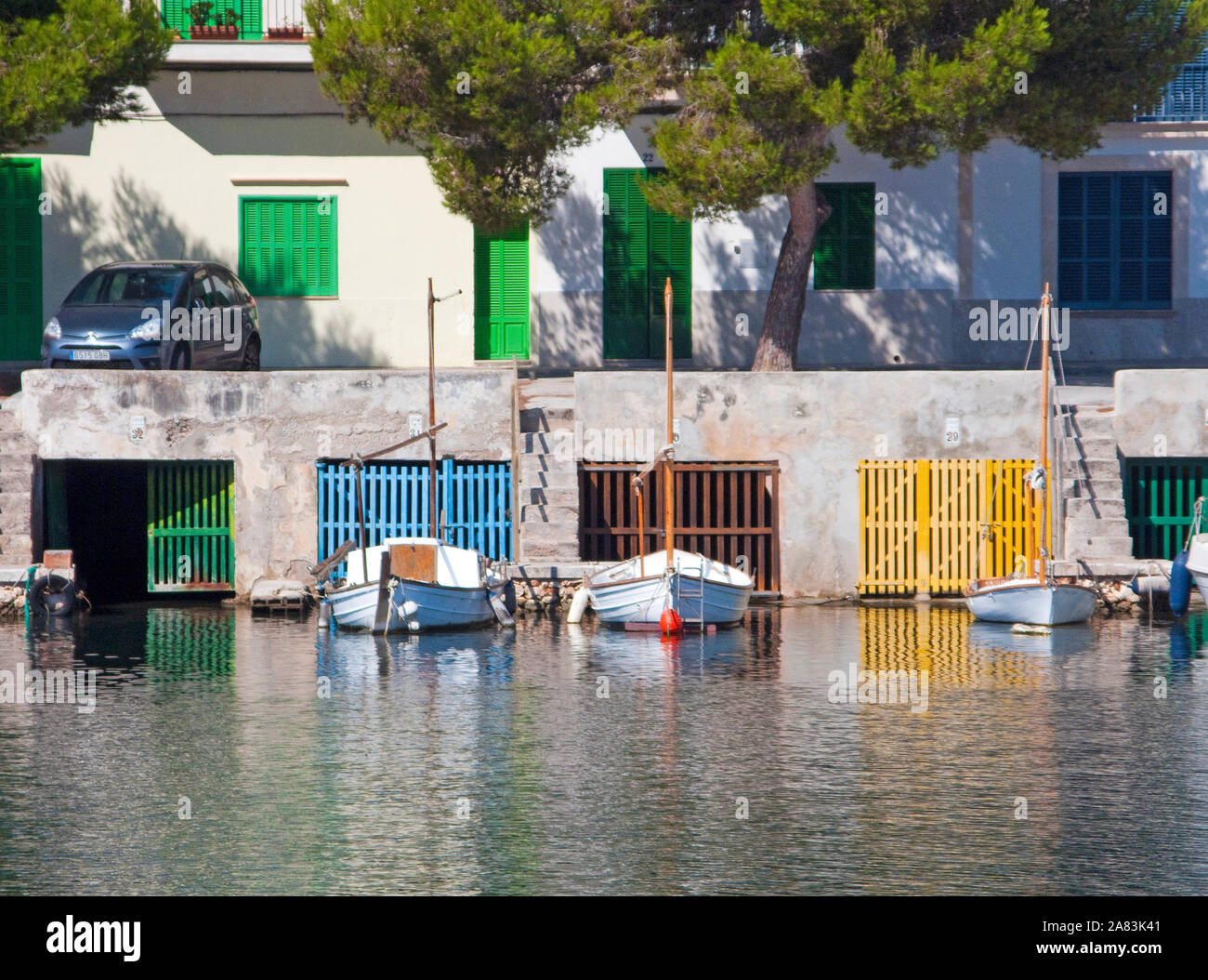 Boot Garagen unter dem ehemaligen Fischerhäuser, historischen Hafen von Porto Colom, Mallorca, Balearen, Spanien Stockfoto