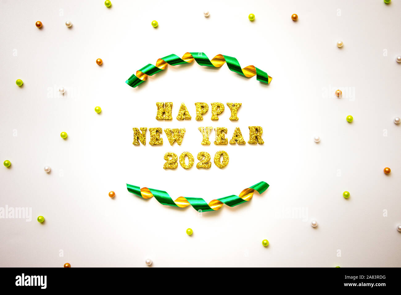 Einfache neue Jahre 2020 Text in Gold Schriftzug happy, gewelltes Band und bunte Perlen auf weißem Hintergrund - Fest- und Feiertage Konzept Stockfoto