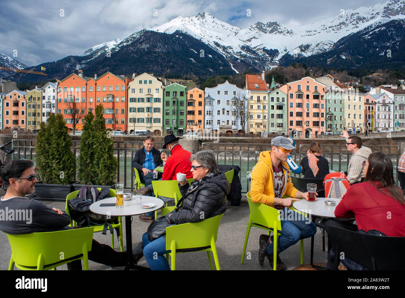 Restaurant und bunten Häuser auf dem Inn mit Schnee Berge hinter, Innsbruck, Tirol, Österreich Stockfoto