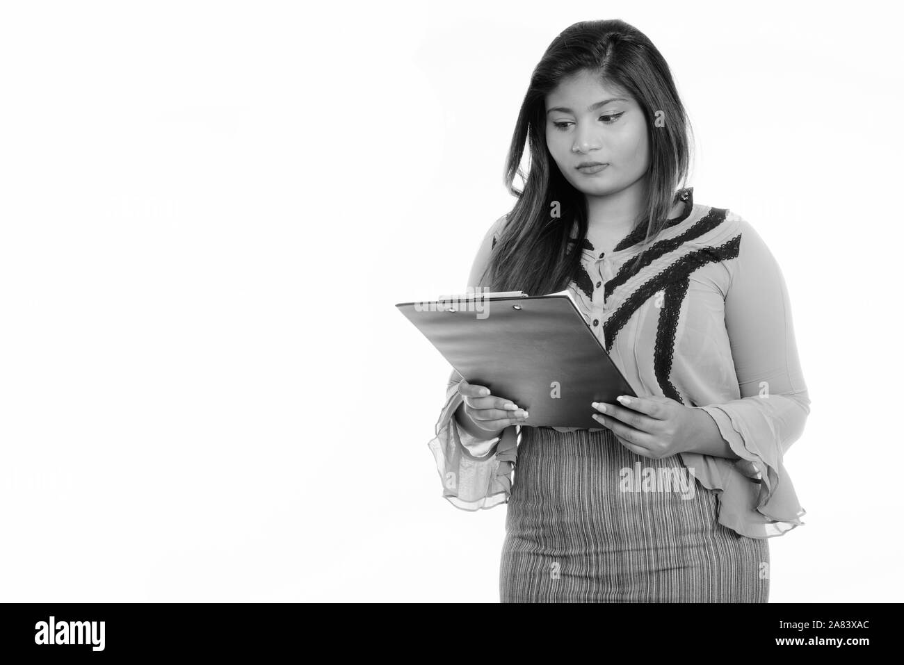Studio shot junger Fett persischen Geschäftsfrau Lesung über Zwischenablage Stockfoto