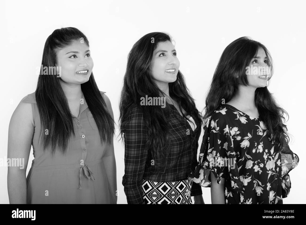 Studio shot von drei glückliche junge persische Frau Freunde lächelnd, während zusammen denken Stockfoto
