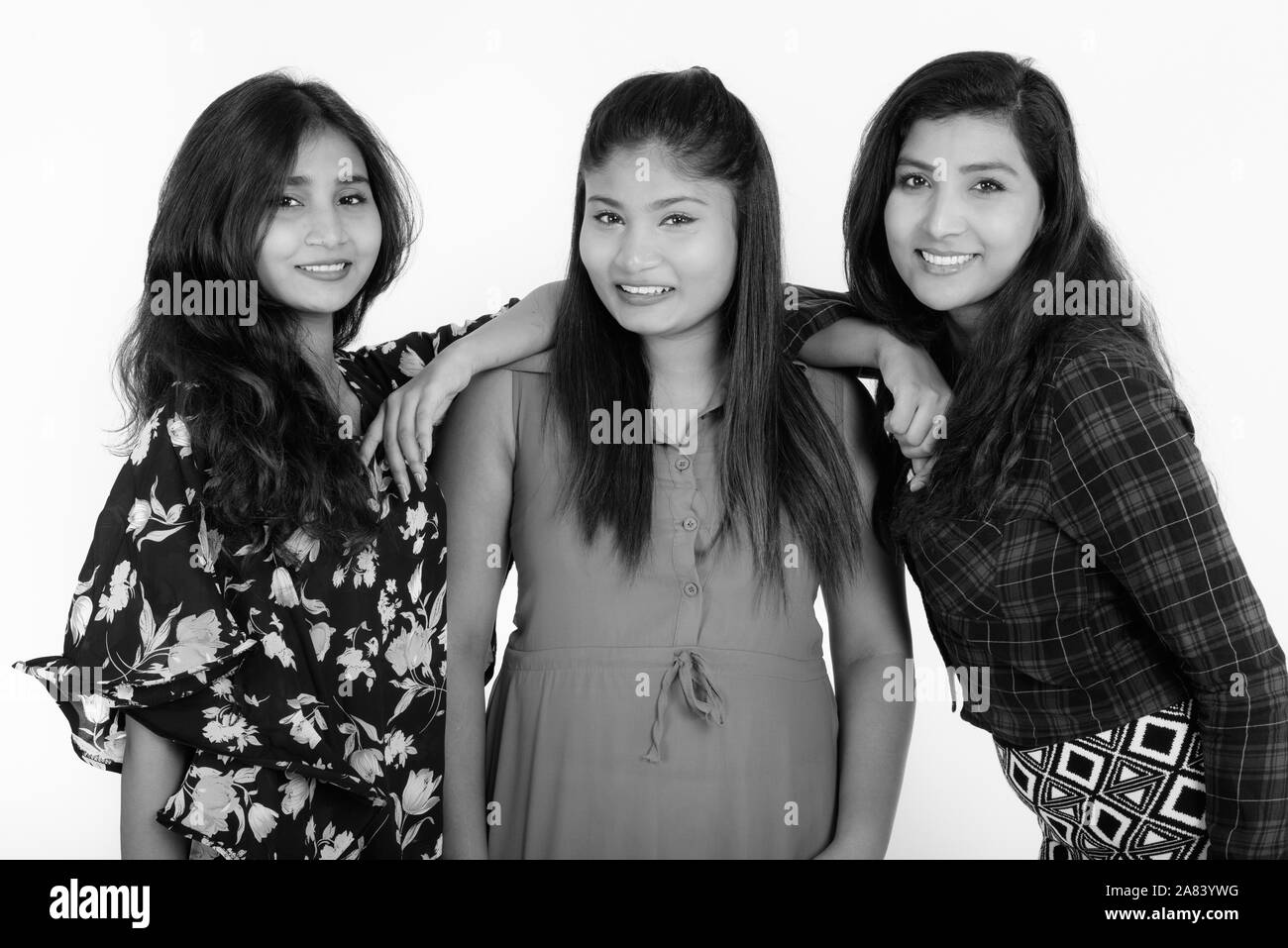 Studio shot von drei glückliche junge persische Frau Freunde lächelnd während lehnte sich auf der Schulter Stockfoto