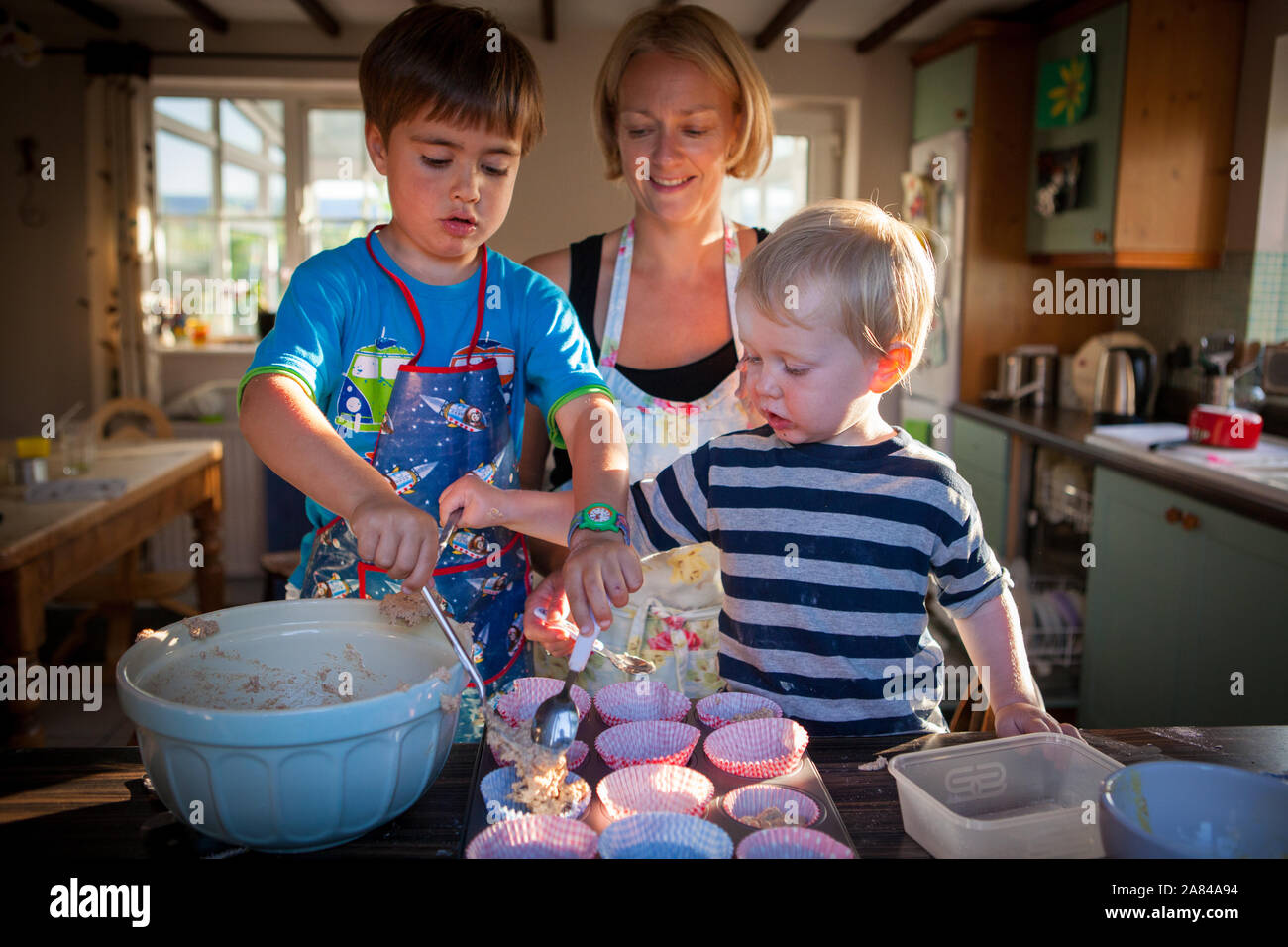 Eine Mutter und ihre beiden Jungen backen zu Hause in der Küche. Stockfoto