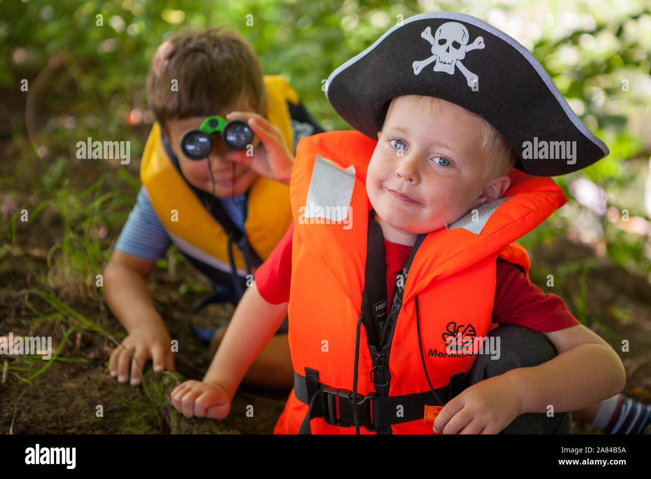 Zwei Jungen gekleidet als Piraten durch die Äste Stockfoto