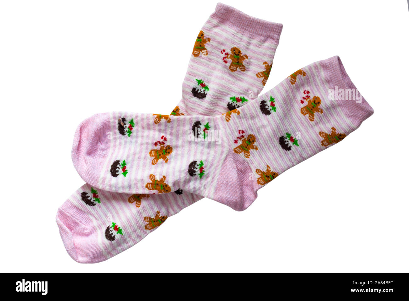 Festliche Mädchensocken, rosa und weiße Streifen mit Weihnachtspuddings und Lebkuchenmännern auf isoliert auf weißem Hintergrund Stockfoto
