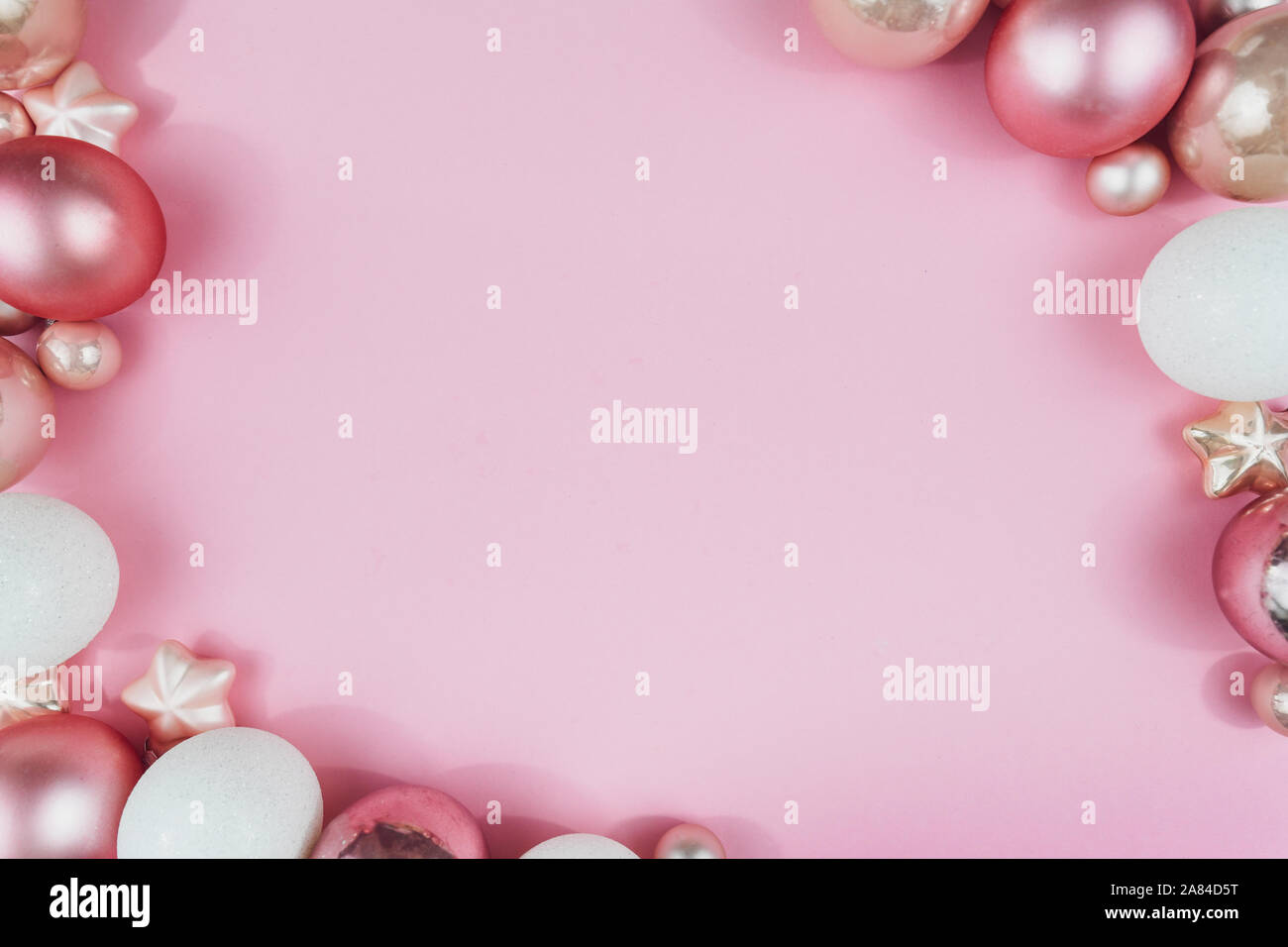 Ansicht von oben flach mit verschiedenen Rosa und Weiß Weihnachtskugel und Stern Ornament auf Pastell rosa Hintergrund Stockfoto