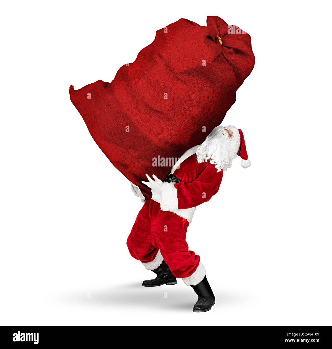 Klassische traditionelle Crazy funny Santa Claus auf anstrengend. Die riesige riesige grosse rote Beutel mit Weihnachtsgeschenk präsentieren auf w isoliert Stockfoto