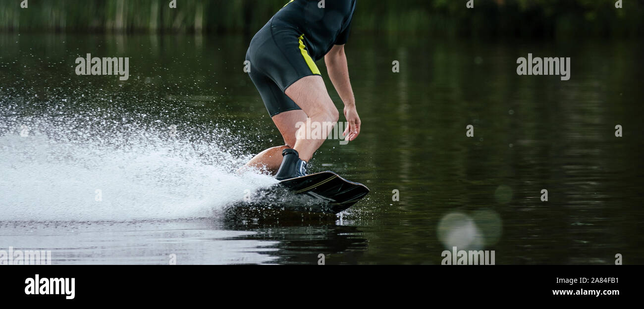 Wakeboarding männlichen Mitfahrer in Wakeboard im Sommer auf See Stockfoto