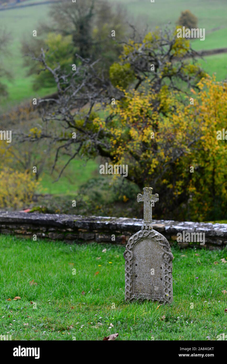 Alter Grabstein in einem kleinen französischen Dorffriedhof mit Blick auf das Tal und die Hügel des südlichen Burgund, umgeben von einer traditionellen Steinmauer Stockfoto