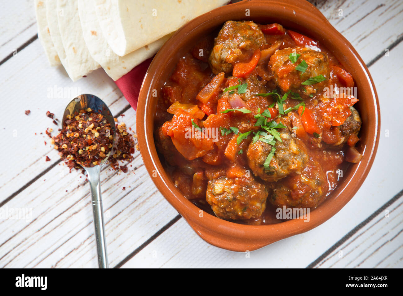 Ein traditionelles türkisches Gericht mit gebackenen Fleischbällchen in Tomaten- und roter Pfeffersauce, serviert mit Orzo-Reis. Mini Sebzeli Kofte. Stockfoto