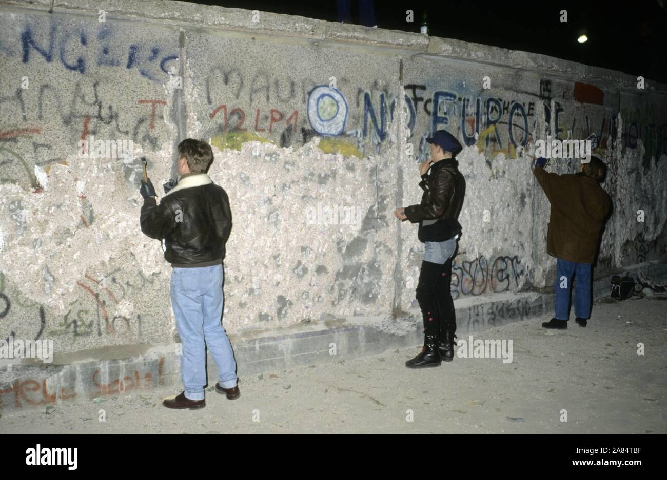 Fall der Berliner Mauer. Im Bild einige Leute mit Hämmern geschlagen der restlichen Wand. Dezember 31, 1989 - Januar 1, 1990, Berlin, Deutschland --- wiedervereinigten deutschen feiern Sie Silvester auf der Berliner Mauer zwei Monate nach der Grenze zwischen dem geteilten Stadt eröffnet. © Thierry Monasse/europolitiquephoto.eu (Monasse/Fotogramma, Berlin - 1989-12-31) ps das Foto kann in Bezug auf den Kontext, in dem es aufgenommen wurde verwendet werden, und ohne beleidigende Absicht der Anstand des Volkes vertreten Redaktionelle Nutzung Stockfoto