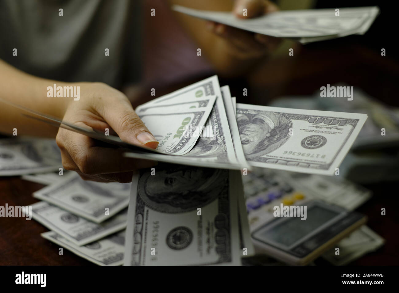 Unternehmer Frauen zählen Geld auf einem Stapel von 100 US-Dollar Banknoten Stockfoto